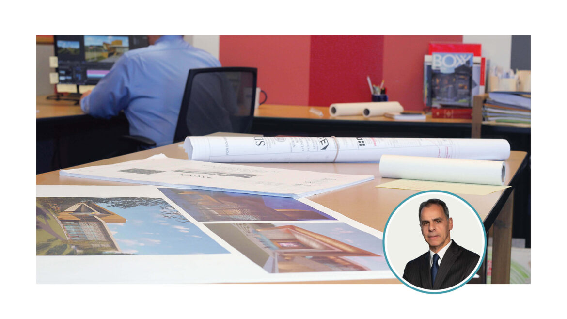 Architectural plans on a desk and the author's photo.
