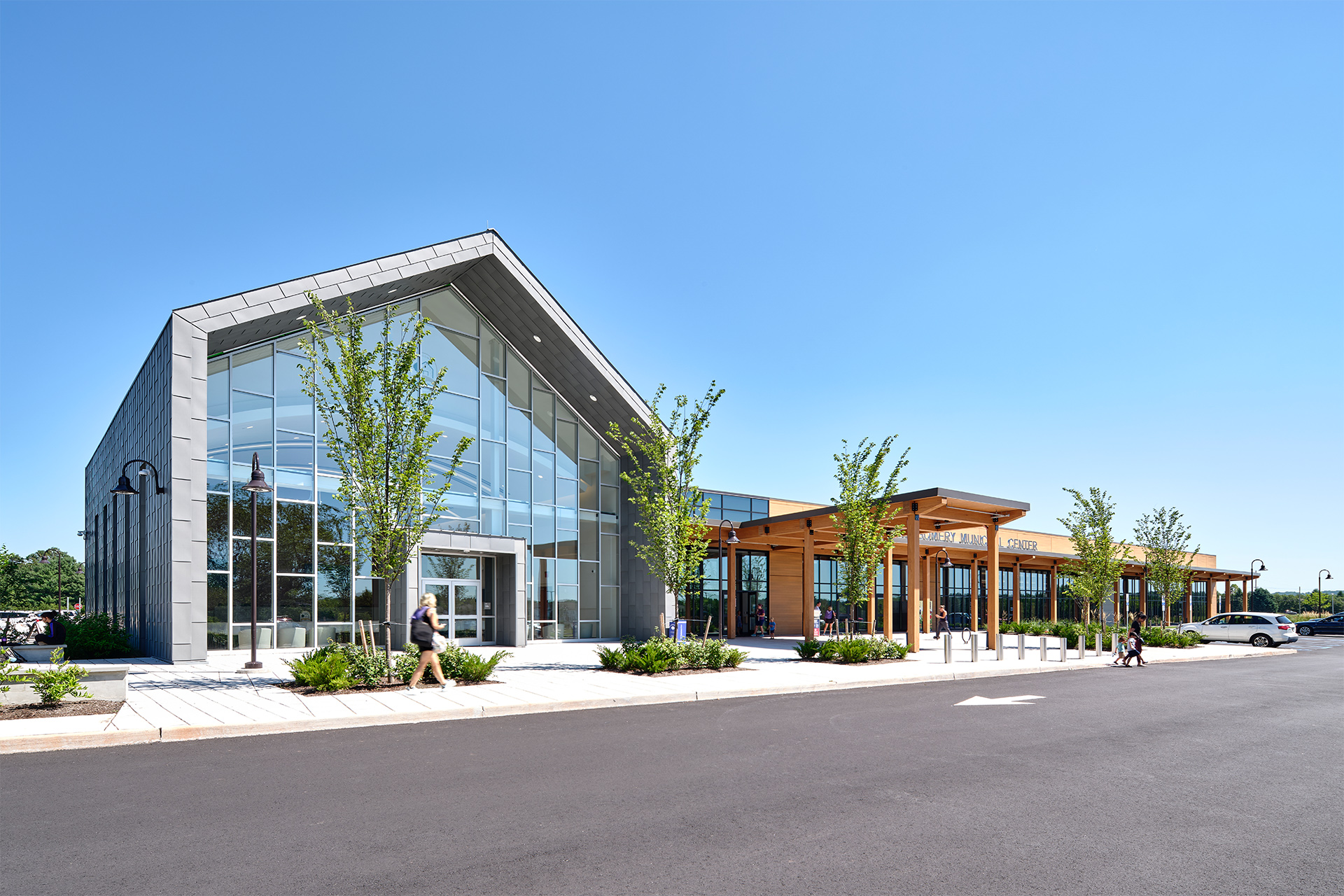 The exterior of the Montgomery Municipal Center. In the foreground is the council chambers, which includes a glass facade a roofline that mimics and gable barn, a nod to the township's agricultural history.