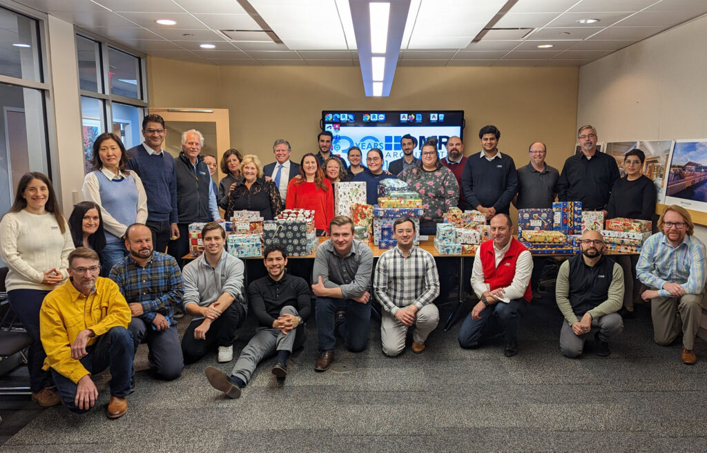 The DMR team poses for a group photo with more than 50 wrapped gifts which were donated to local children.