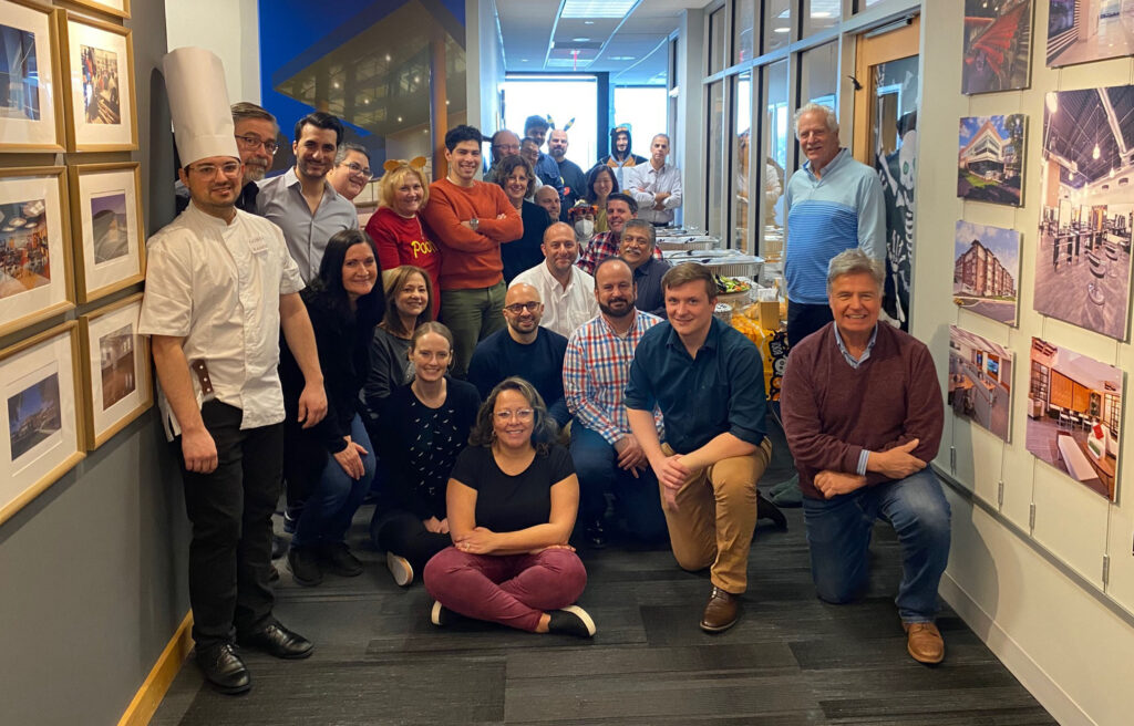 The DMR team poses for a group photo before a lunch on Halloween. Some employees are dressed in costumes.