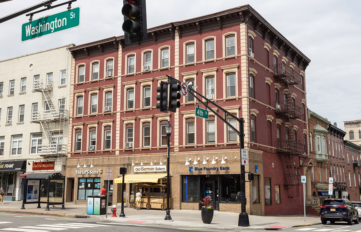 The retail options, including the UPS Store and a bakery, surounding Blue Foundry Bank on the busy Washington Street in Hoboken, NJ.