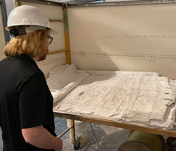 An architect reviewing plans at a construction site.