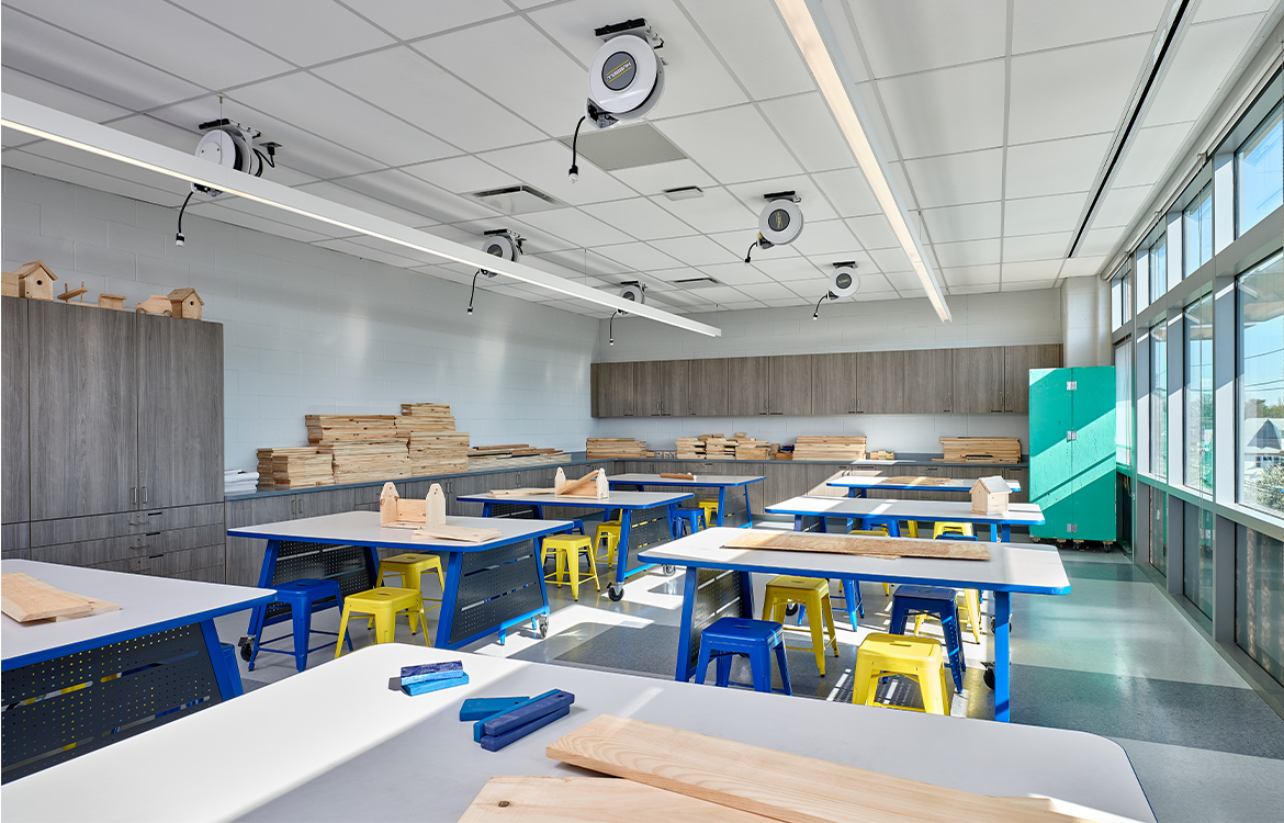 The wood shop at Carteret Junior High School includes moveable work benches and electrical utilities hung from the ceiling.