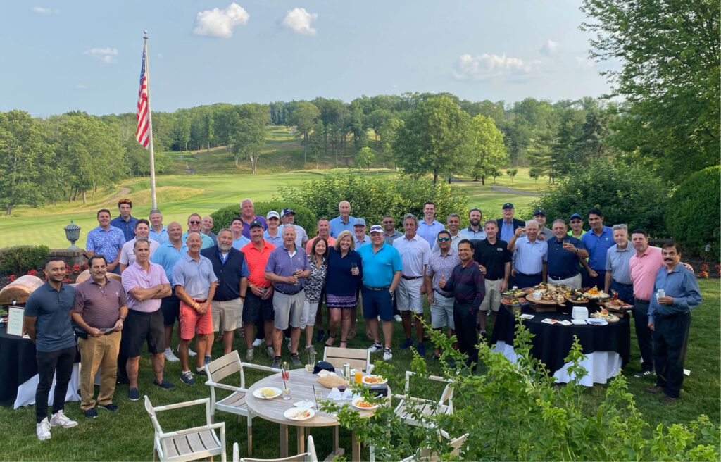 Attendees of the 2023 DMR Foundation Golf Classic gather for a group photo overlooking the golf course.