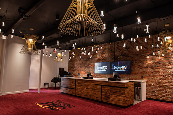 The new VIP area of bergenPAC, showing a bar and point-of-sale system in a space that includes eclectic light installations and exposed brick.