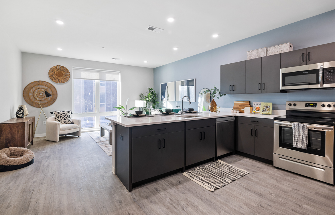 A sample unit at The Vale shows an open concept kitchen and living room, with a breakfast bar.
