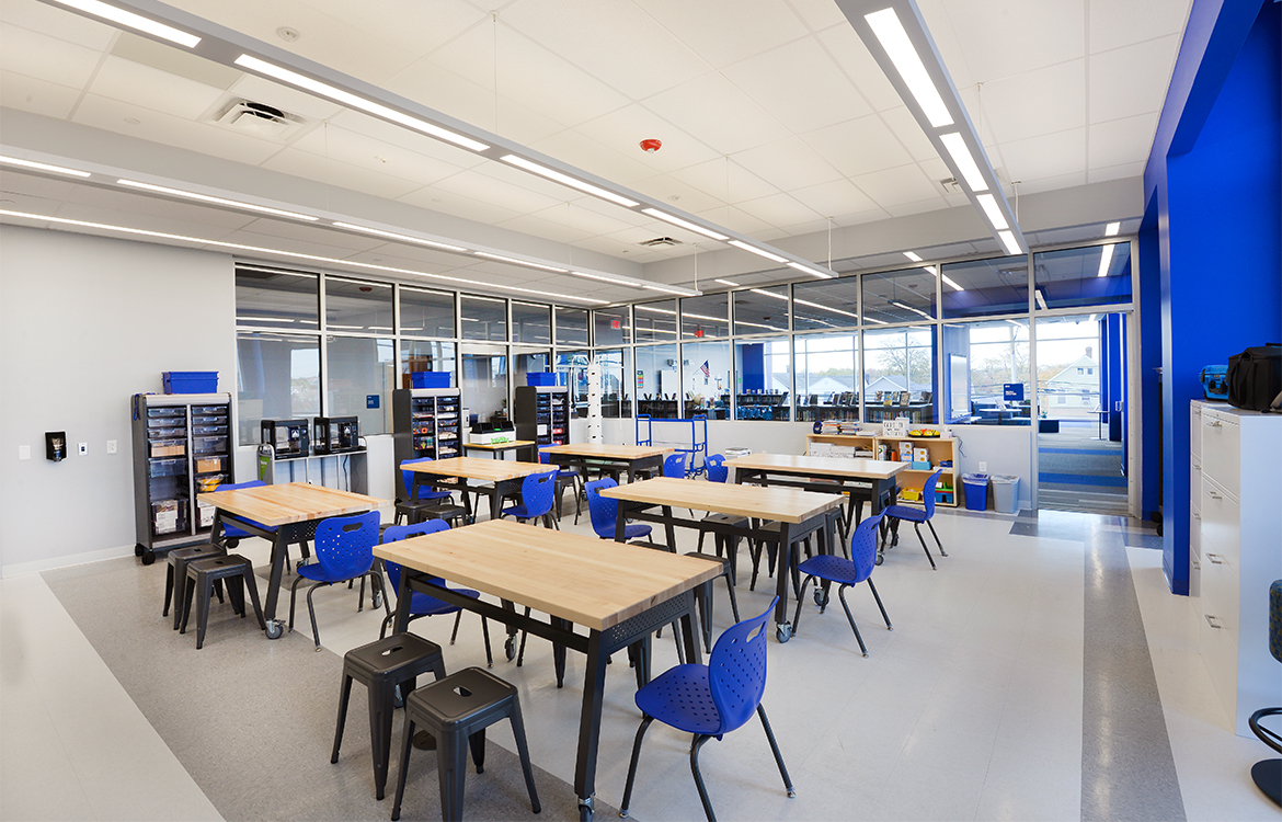 The makerspace at the Blanquita B. Valenti Community School in enclosed in glass and is adjacent to the library. The space includes workstations on wheels and 3D printers.