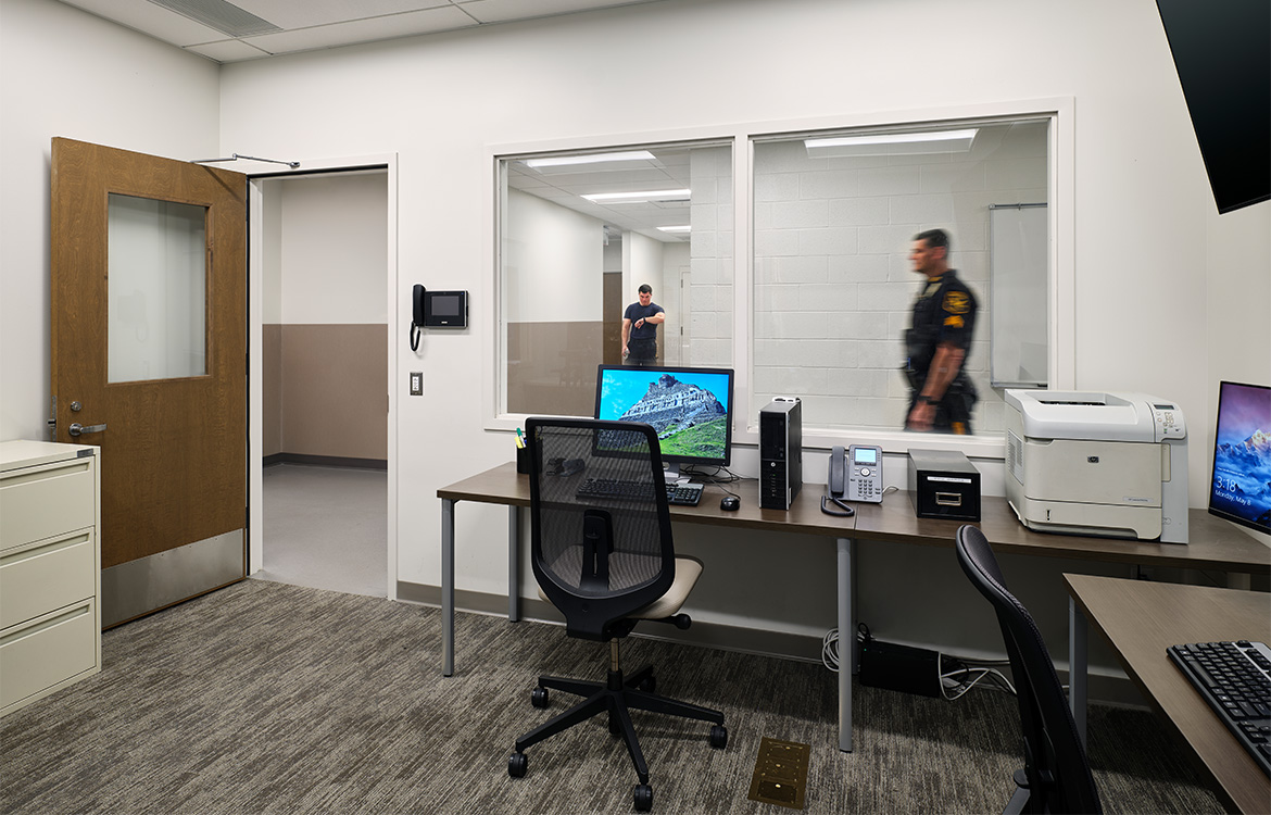 Police officers are seen walking through the Ridgefield Police Department from the muster room.