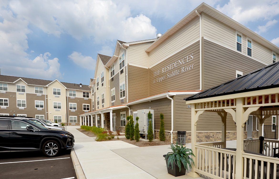 The exterior of The Residences at Upper Saddle River, which also shows the patio and gazebo located outside of main gathering and socialization area.