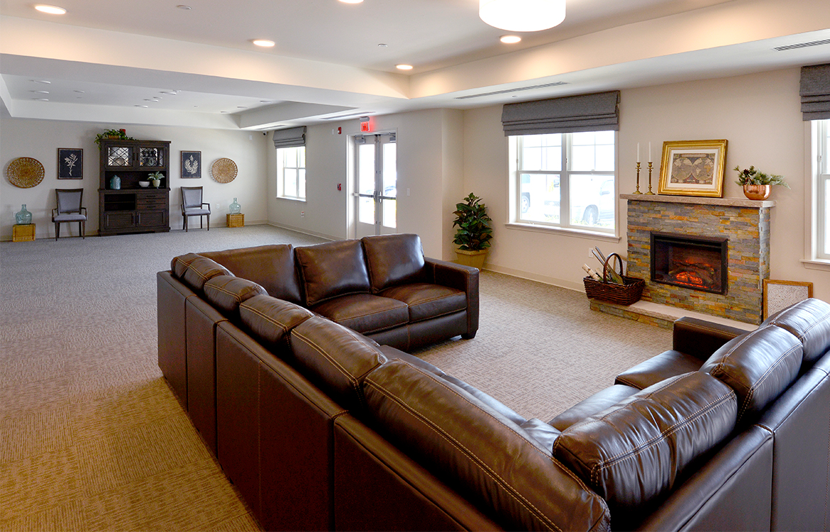 An oversized sofa in a large gathering area for residents at The Residences at Upper Saddle River, demonstrating the variety of gathering and socialization options.